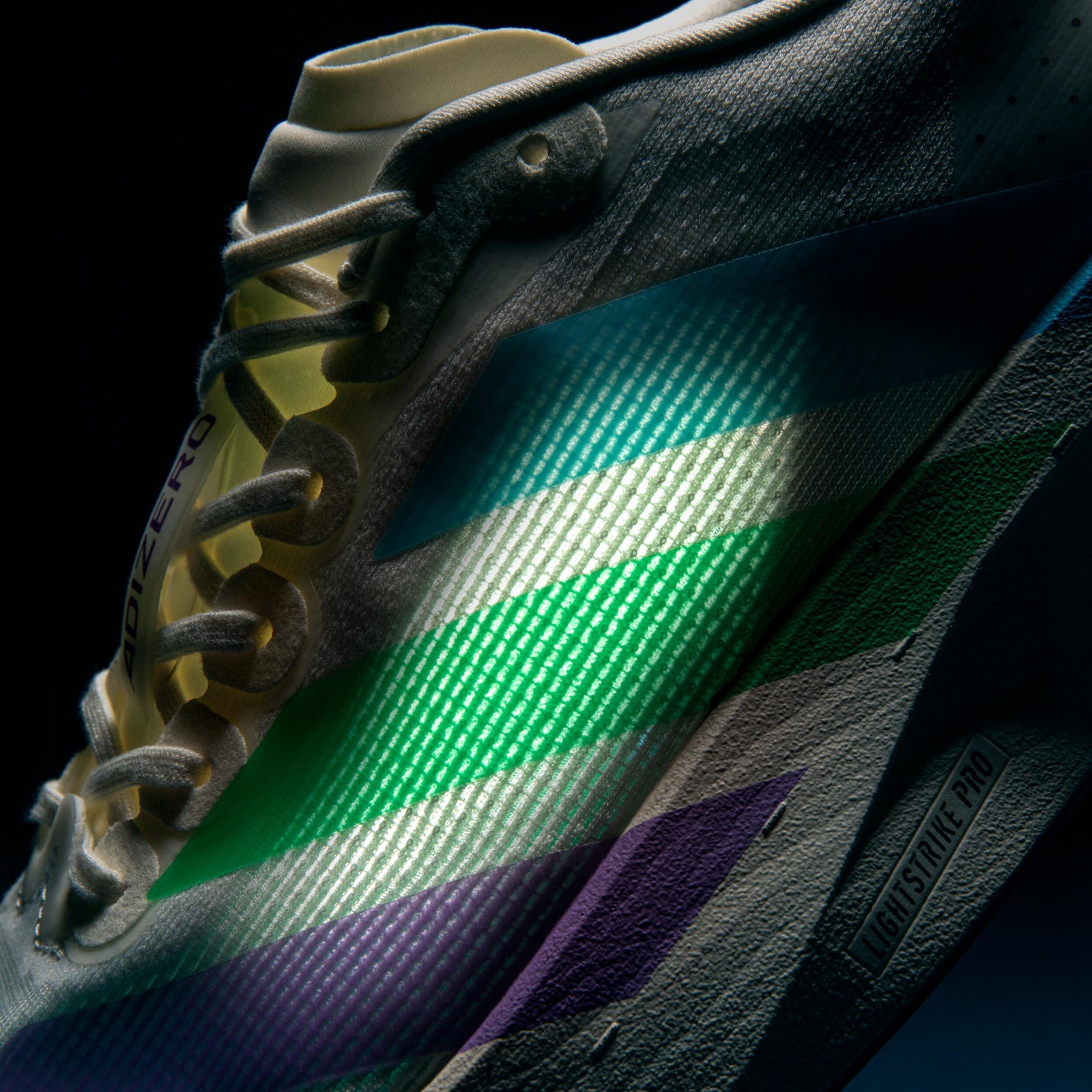 The adidas Adizero Evo SL SNS stripes glowing green and blue under low light, showing the color-shift effect