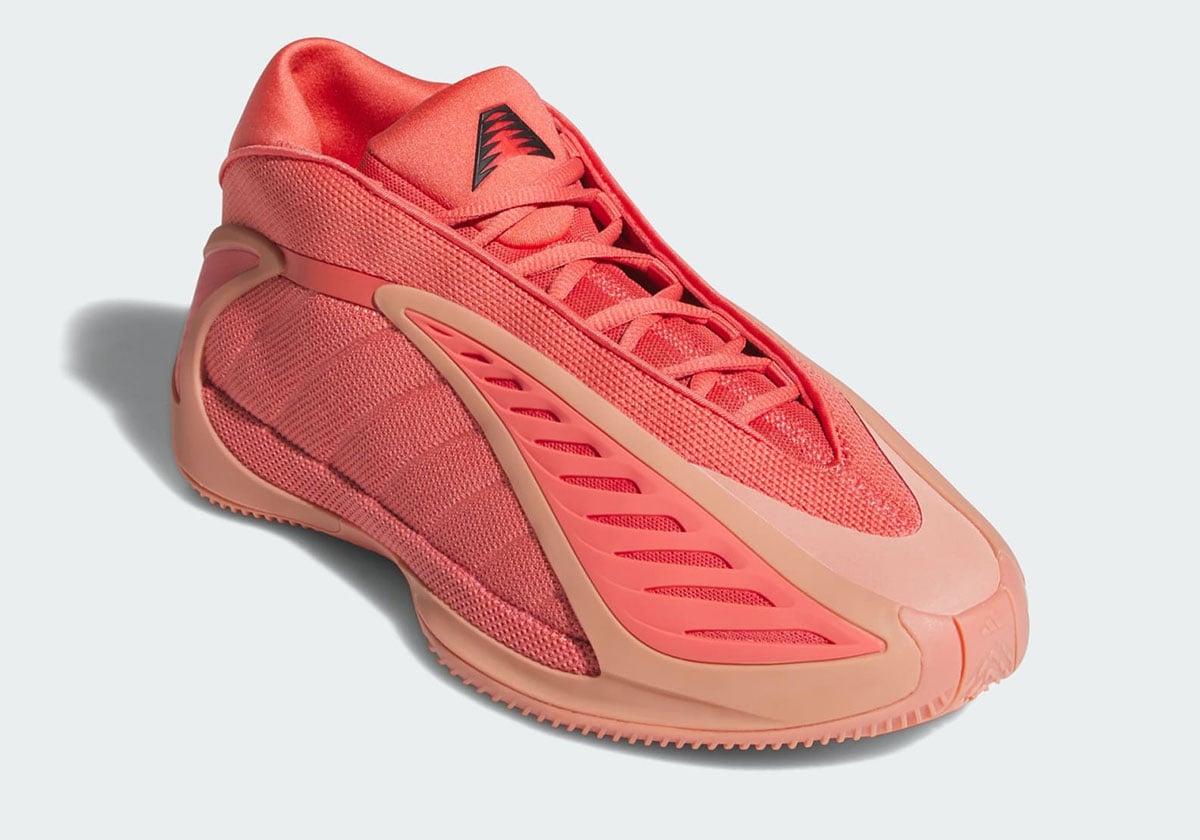 Front three-quarter look at the coral Anthony Edwards 2, showing the salmon midfoot wing and AE logo on the tongue