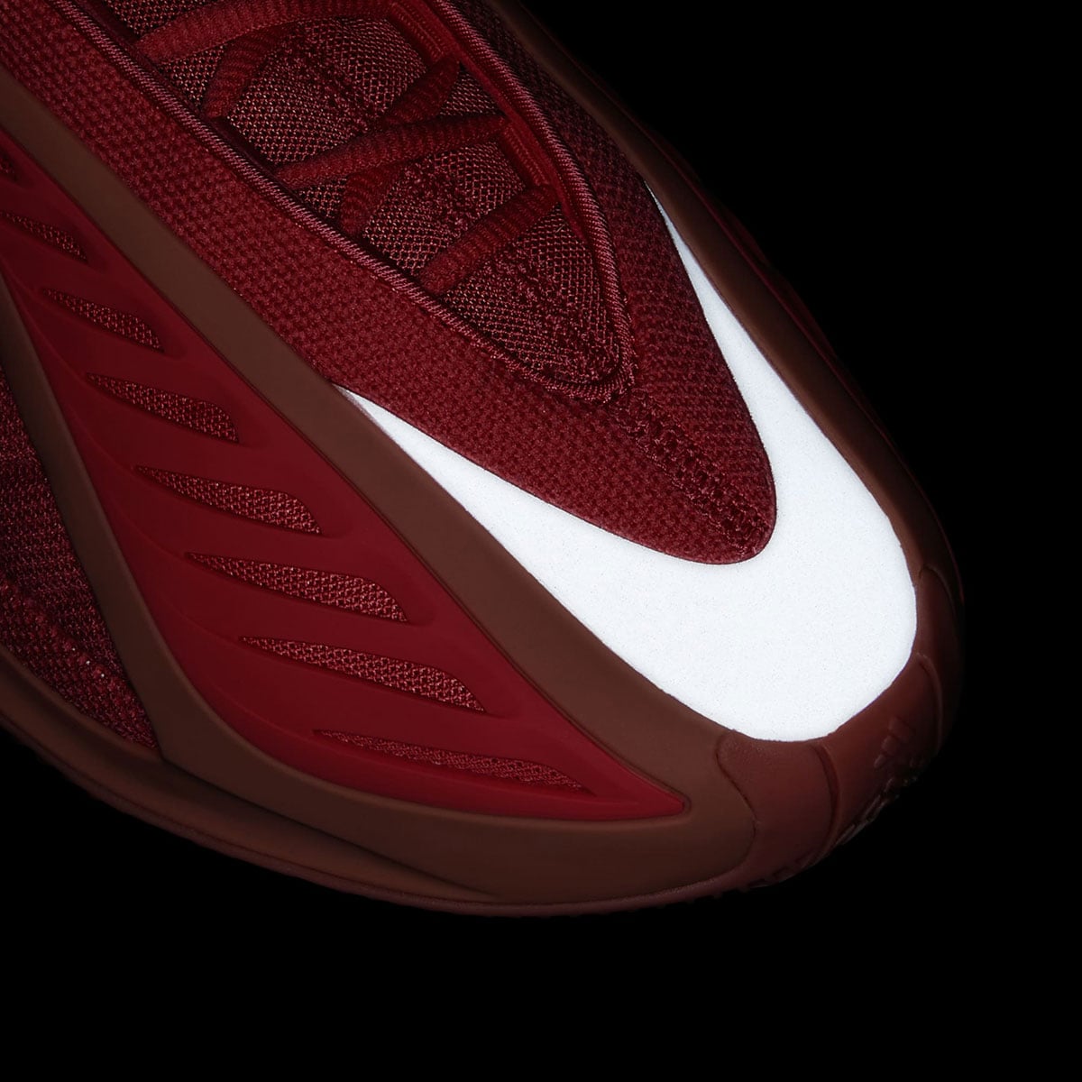Dramatic macro of the forefoot wing on the Anthony Edwards 2, deep red knit framing a bright white midsole edge