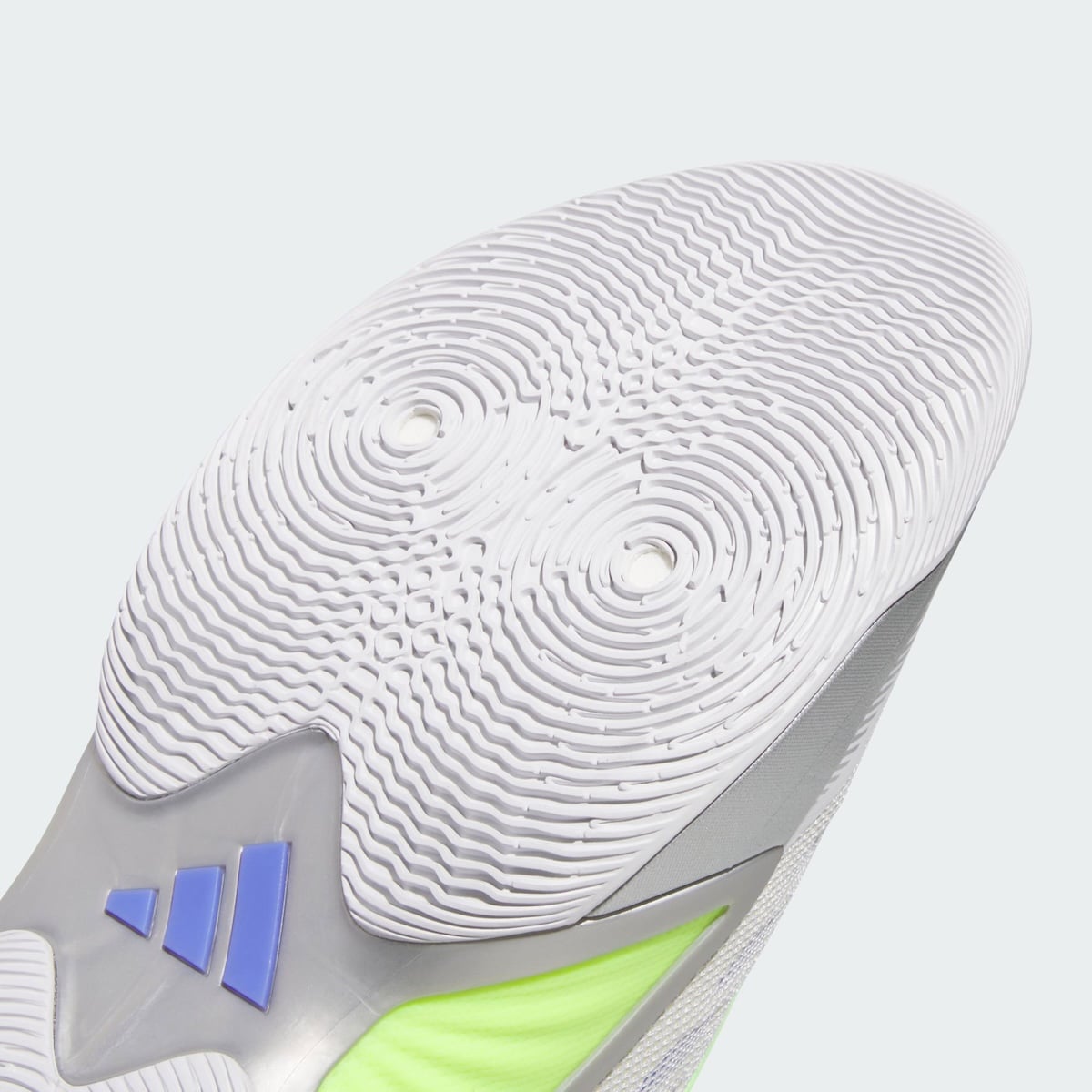 Heel outsole detail of the Silver Spida showing circular pivot traction and a blue Three Stripes mark