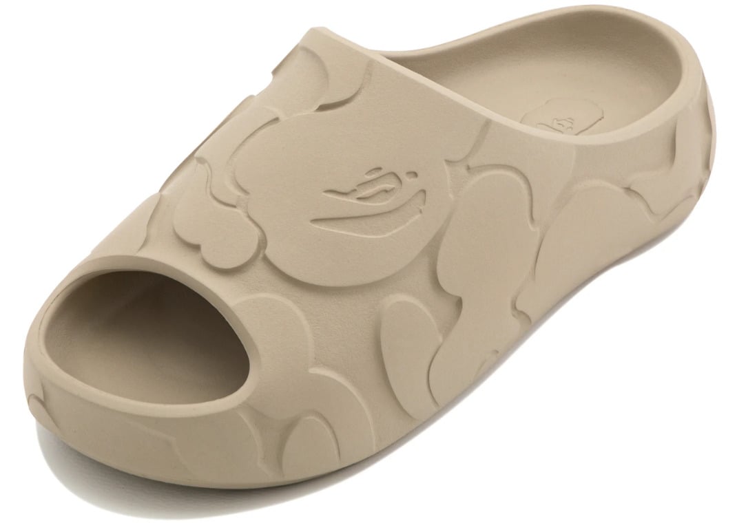 Top-down view of the beige slide with the recessed ape head logo sitting on the forefoot strap