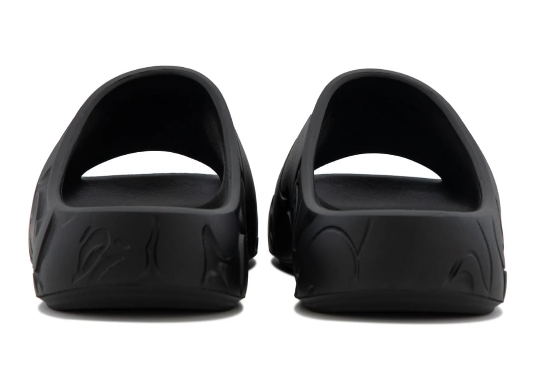 Heel view of the black pair with the molded camo texture wrapping the back of each slide