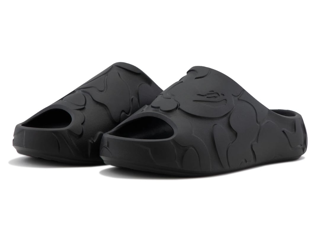 Front three-quarter look at the black BAPE Slide, the camo relief reading tonal across the matte foam