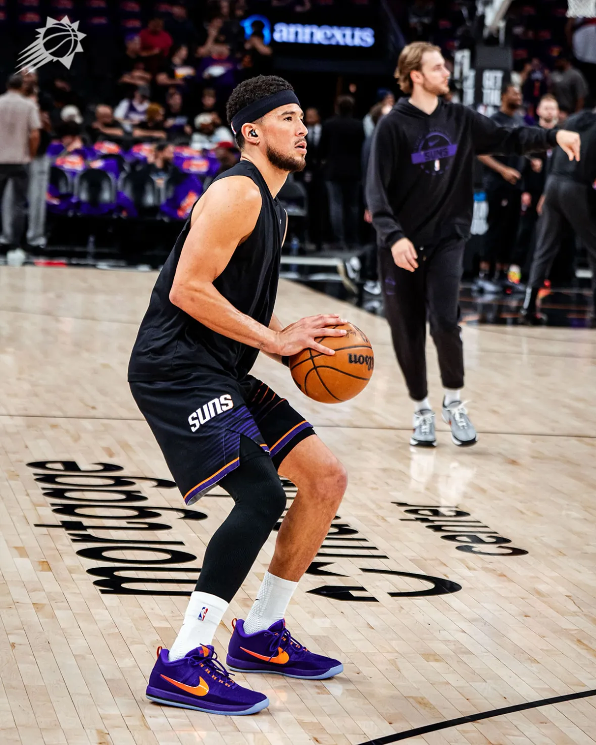 Devin Booker on court in Phoenix during warmups in the Book 2 Sunburst PE with its icy blue outsole