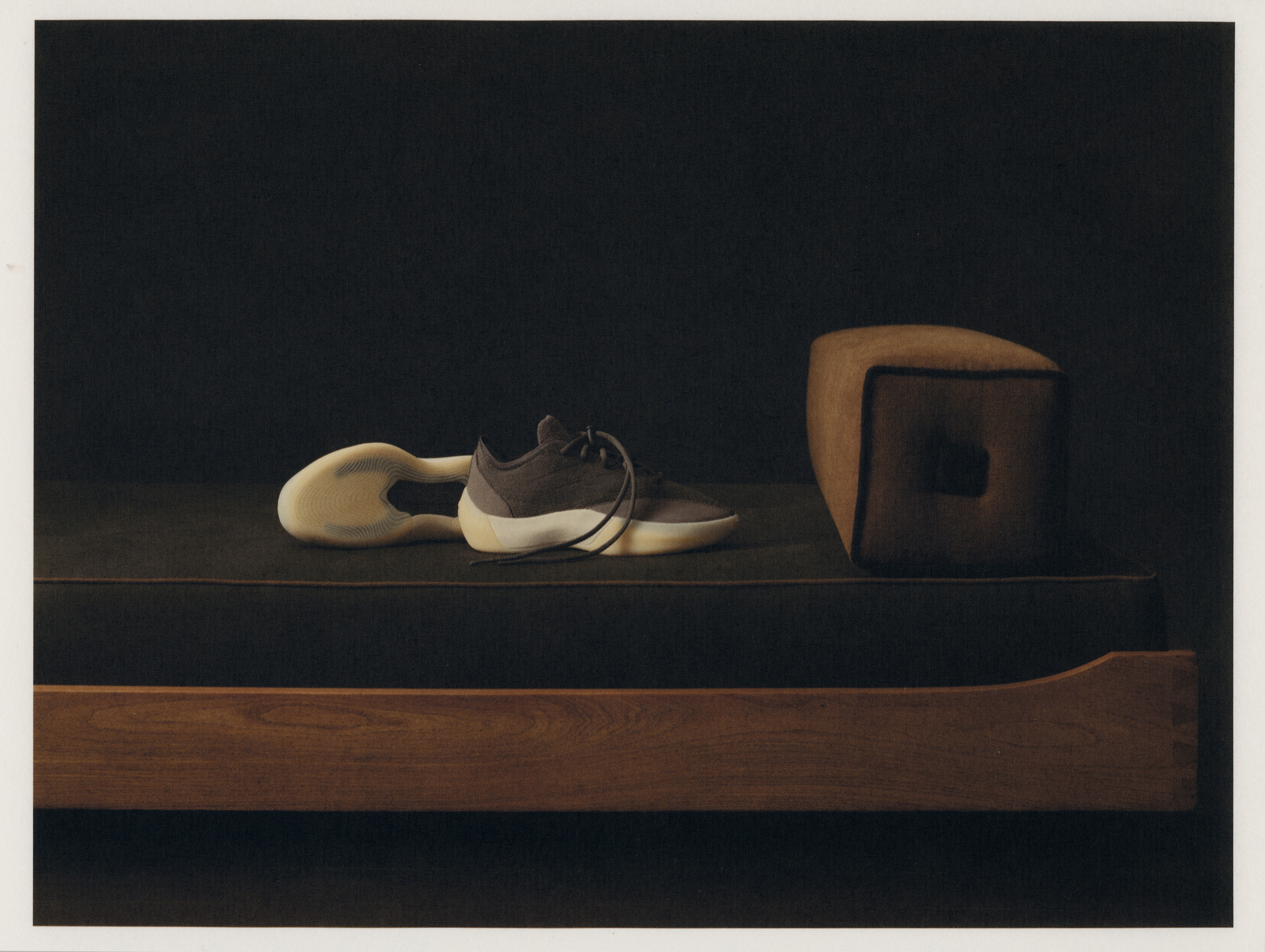 Fear of God Athletics III Basketball "Cinder" on a dark bench with the sole unit displayed alongside