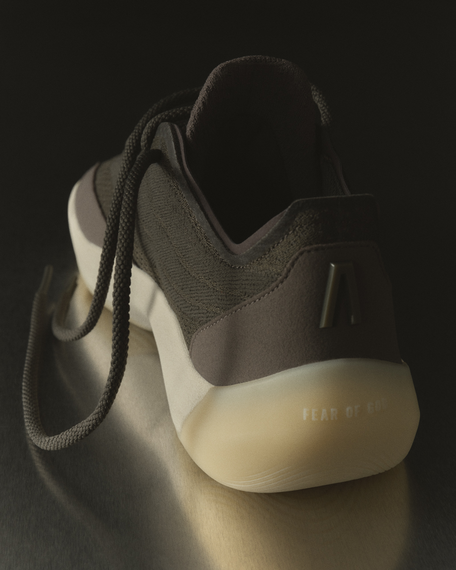 Heel close-up of the Fear of God Athletics III Basketball "Cinder" showing the FEAR OF GOD midsole wordmark and Athletics A logo