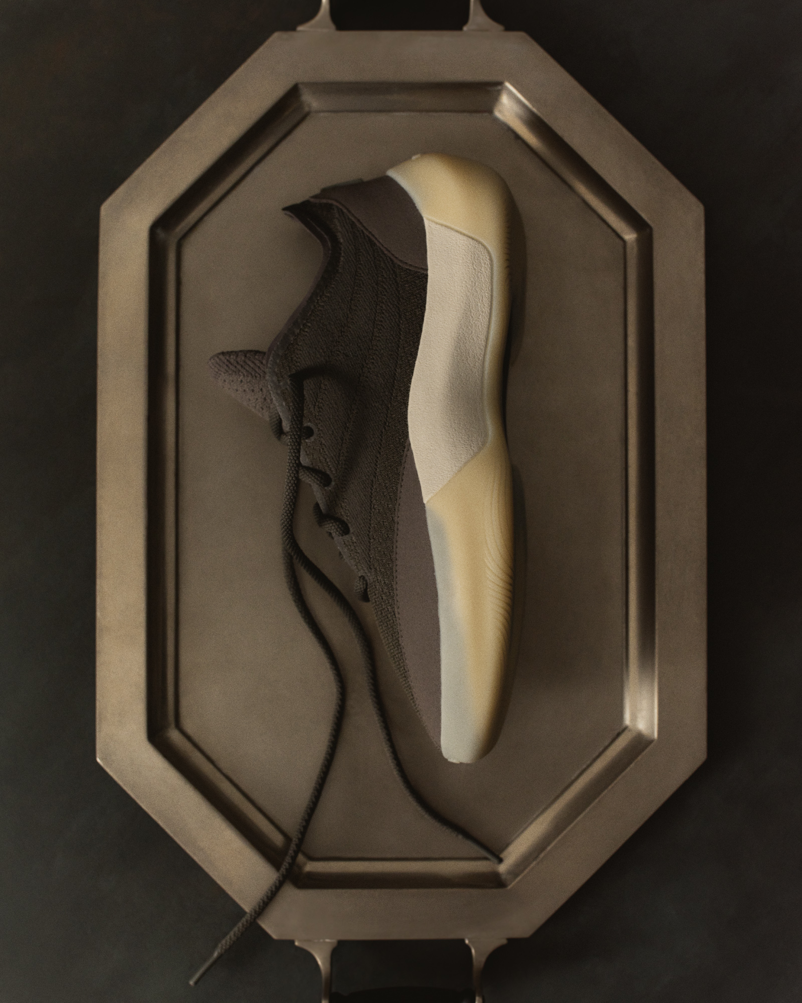Editorial hero shot of the Fear of God Athletics III Basketball "Cinder" displayed inside an octagonal silver tray