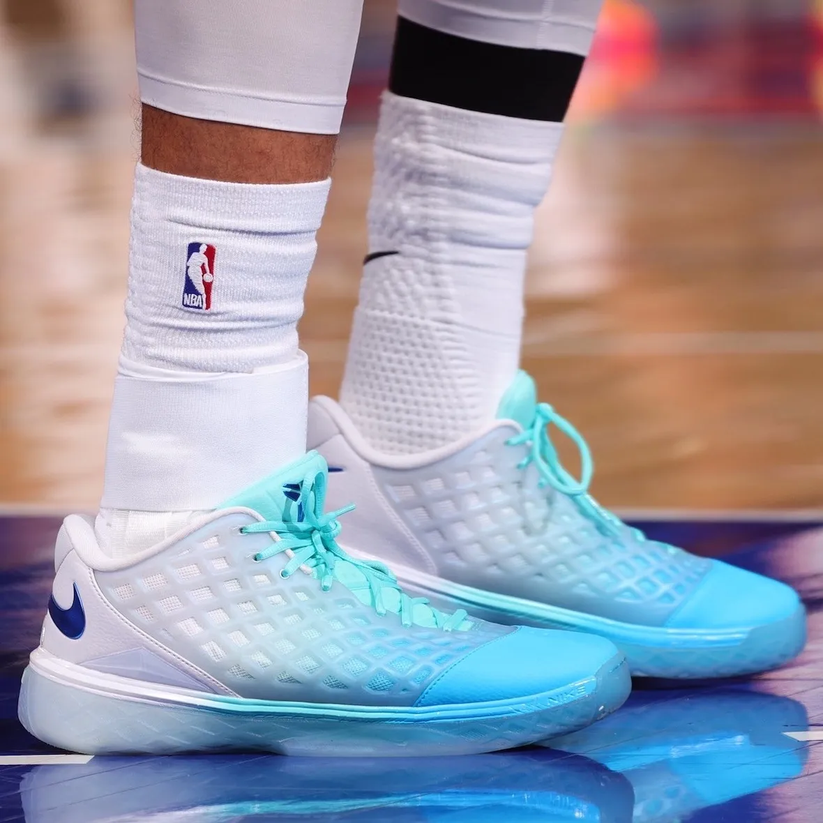 Tight on-foot view of the aqua and sky blue Kobe 3 Low PE, showing the white waffle-textured upper and royal blue heel Swoosh
