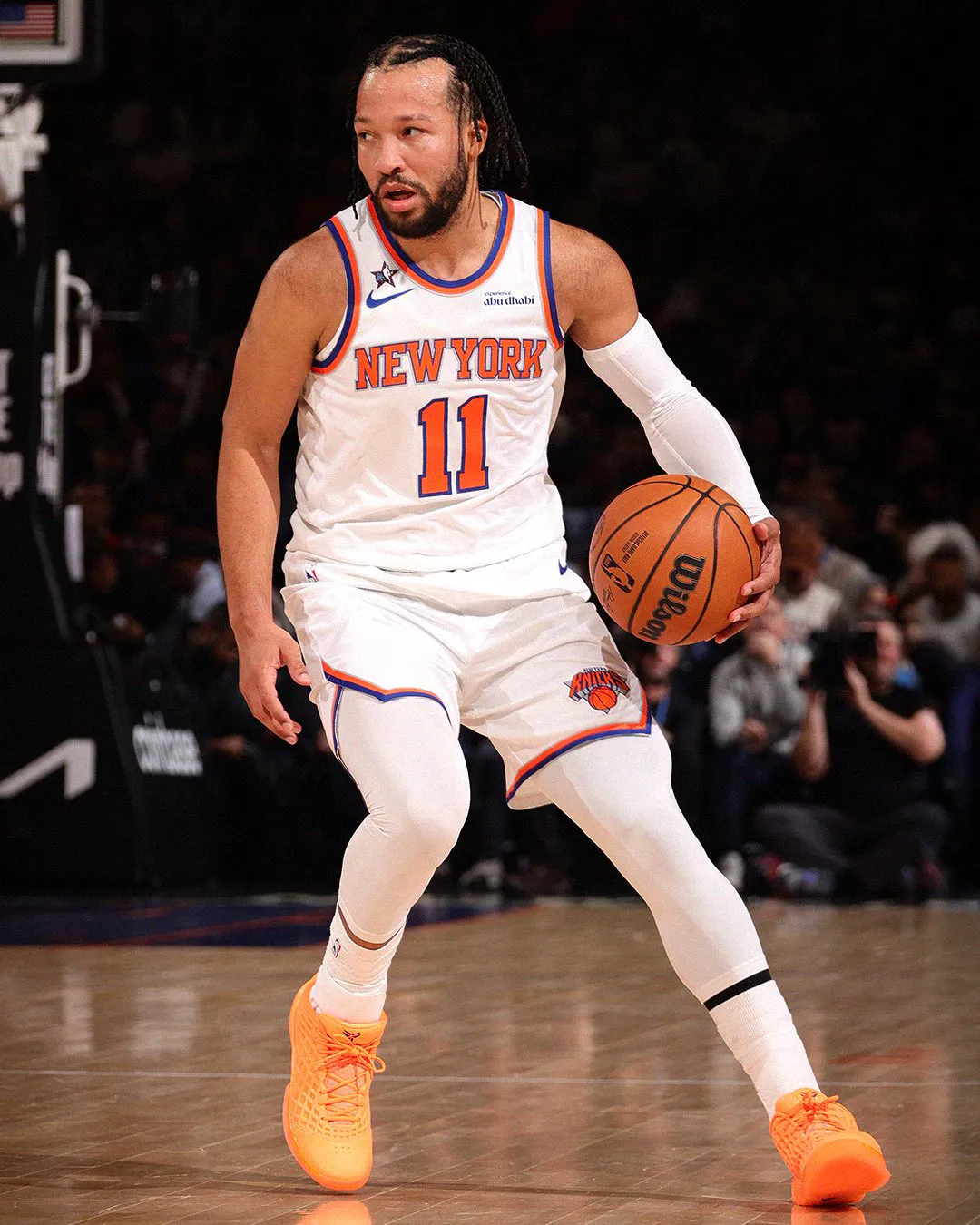 Jalen Brunson dribbling in his white New York Knicks home jersey while wearing the orange Nike Kobe 3 Low PE