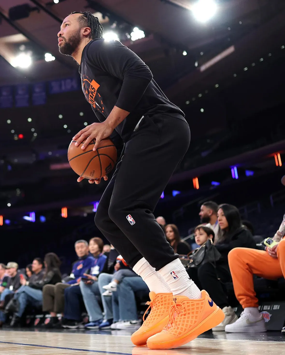 Jalen Brunson warming up at Madison Square Garden in the Nike Kobe 3 Low Knicks PE, all-orange with a blue heel Swoosh