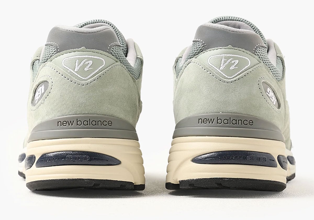 Heel view showing the grey V2 logo and debossed new balance branding on the cream FuelCell midsole