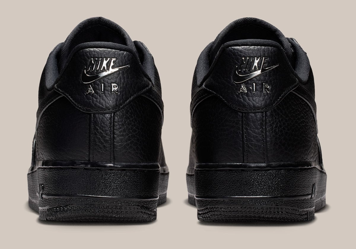 Heel view of the pair with chrome NIKE AIR branding foiled onto the pebbled black leather heel tabs
