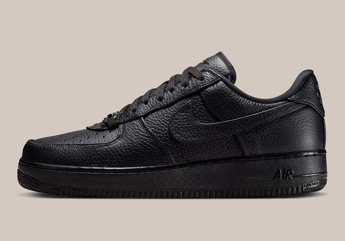 Lateral profile of the black pebbled-leather Air Force 1 Low with a tonal blacked-out Swoosh and AIR midsole branding