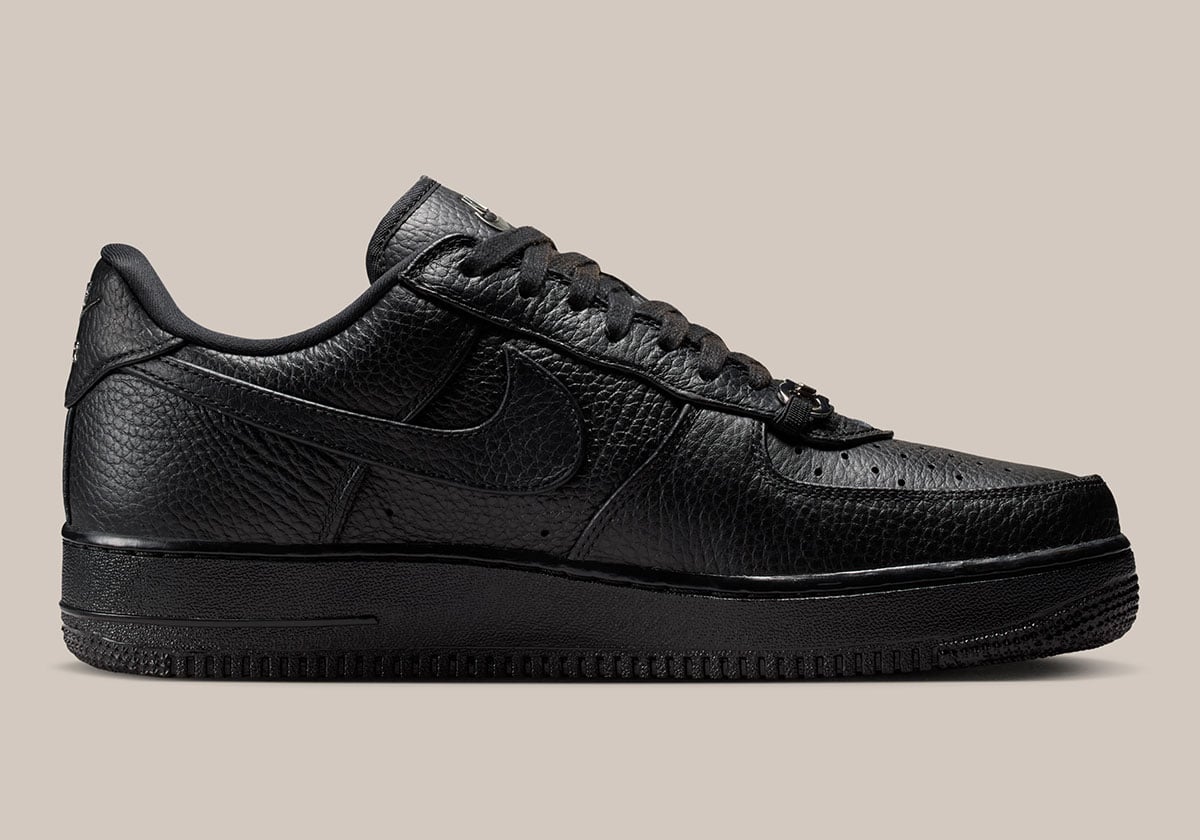 Medial profile of the loafer-buckle Air Force 1 Low showing the chrome heel tab and pebbled leather upper