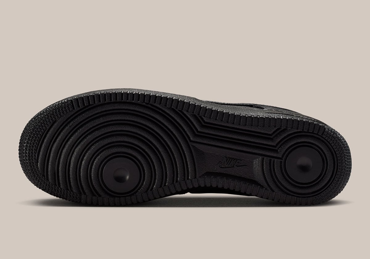 Underside of the all-black Air Force 1 Low outsole with the pivot circles and debossed NIKE text