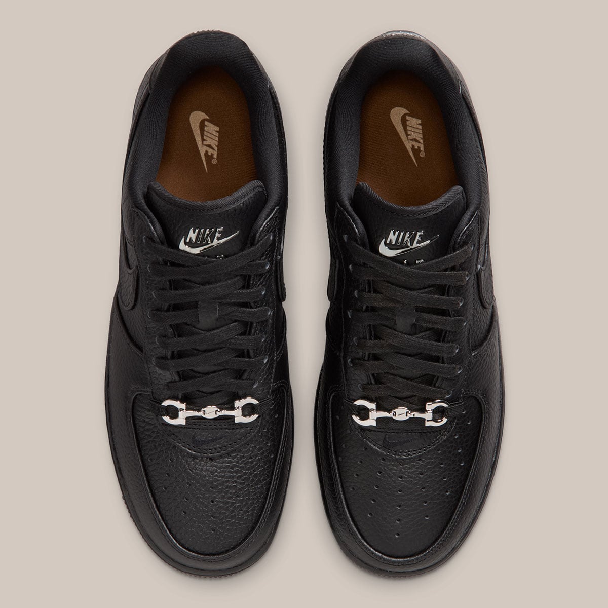 Top-down view of the loafer buckle accents and the tan leather sockliner inside the black Nike Air Force 1 Low