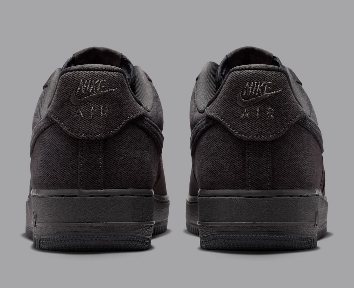 Heel view of the denim Air Force 1 Low with embossed Nike Air branding on the dark grey heel tabs