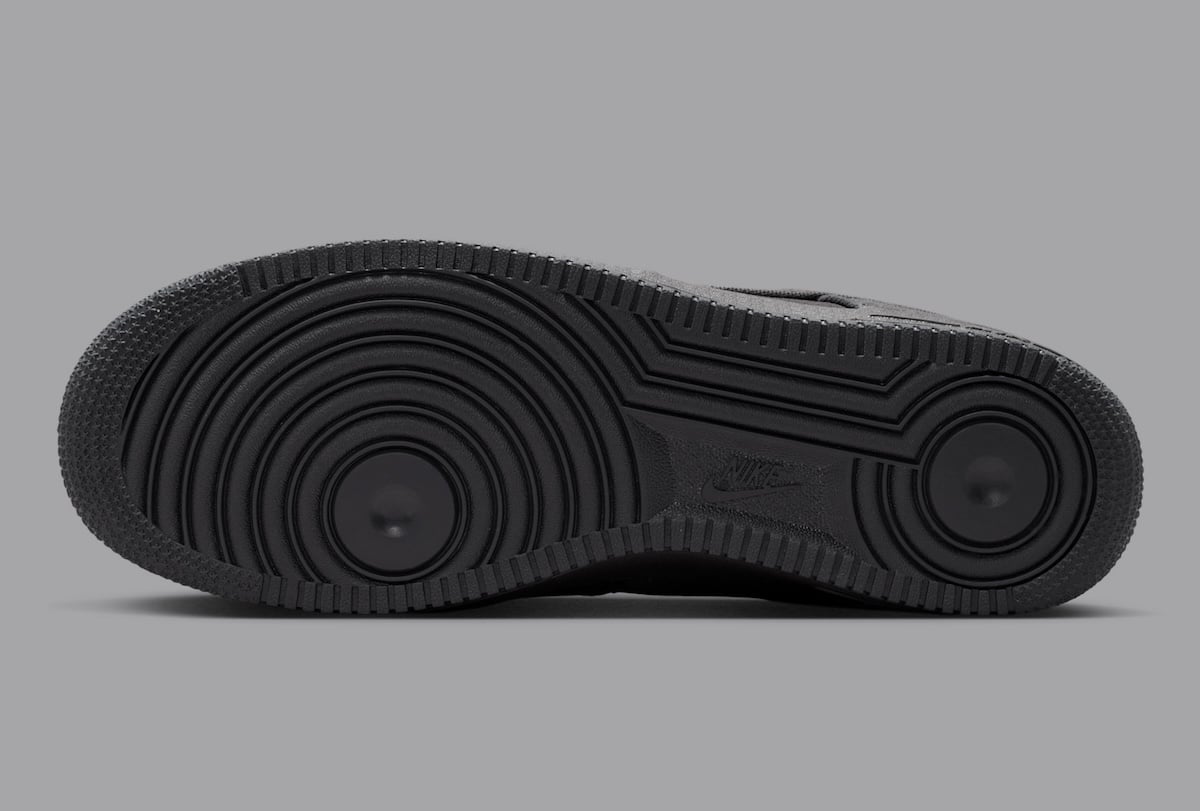 Black rubber outsole of the Air Force 1 Low Denim with embossed Nike branding across the tooling