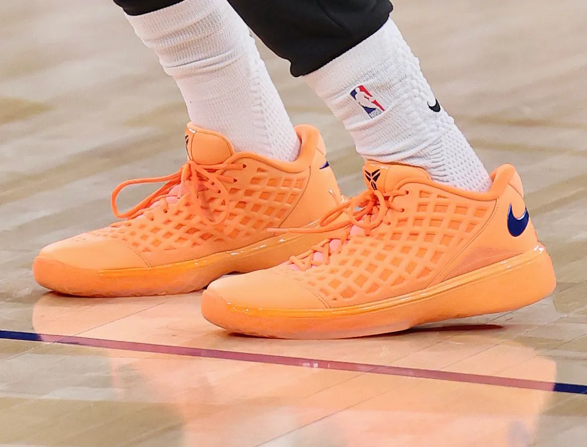 On-foot pair shot of the Nike Kobe 3 Low "Arancia", all-orange lattice upper with a deep blue Swoosh and Kobe sheath logo
