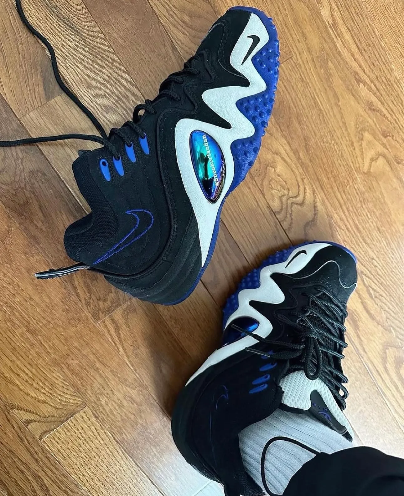Top-down on-foot view of the black and royal blue Nike Zoom Flight 5 pair on a hardwood floor