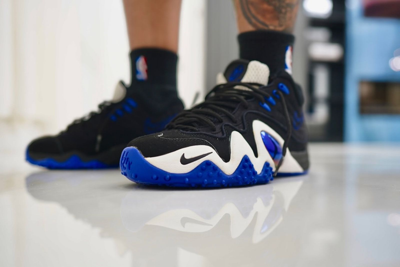 Front three-quarter look at the Nike Zoom Flight V pair on foot, showing the iridescent jewel panel and blue spiked outsole