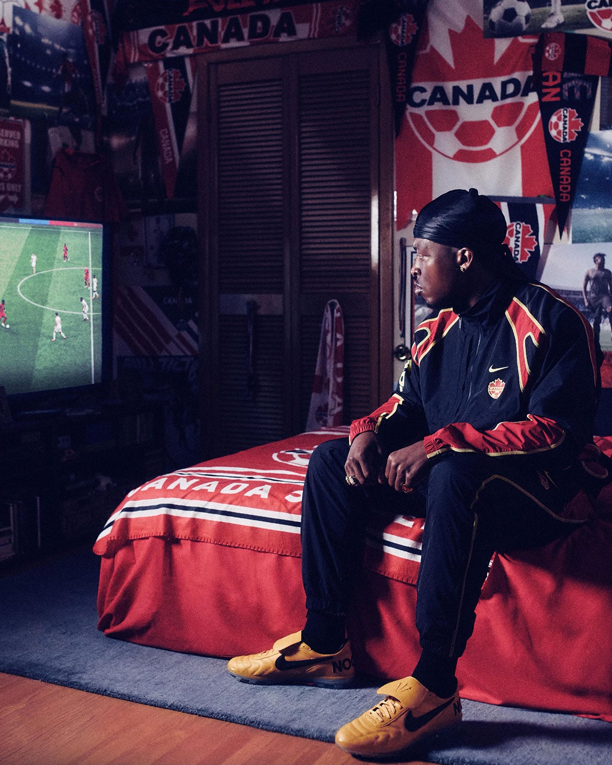 Model in a Canada Soccer bedroom wearing the wheat suede NOCTA Nike Cryoshot with a black Swoosh