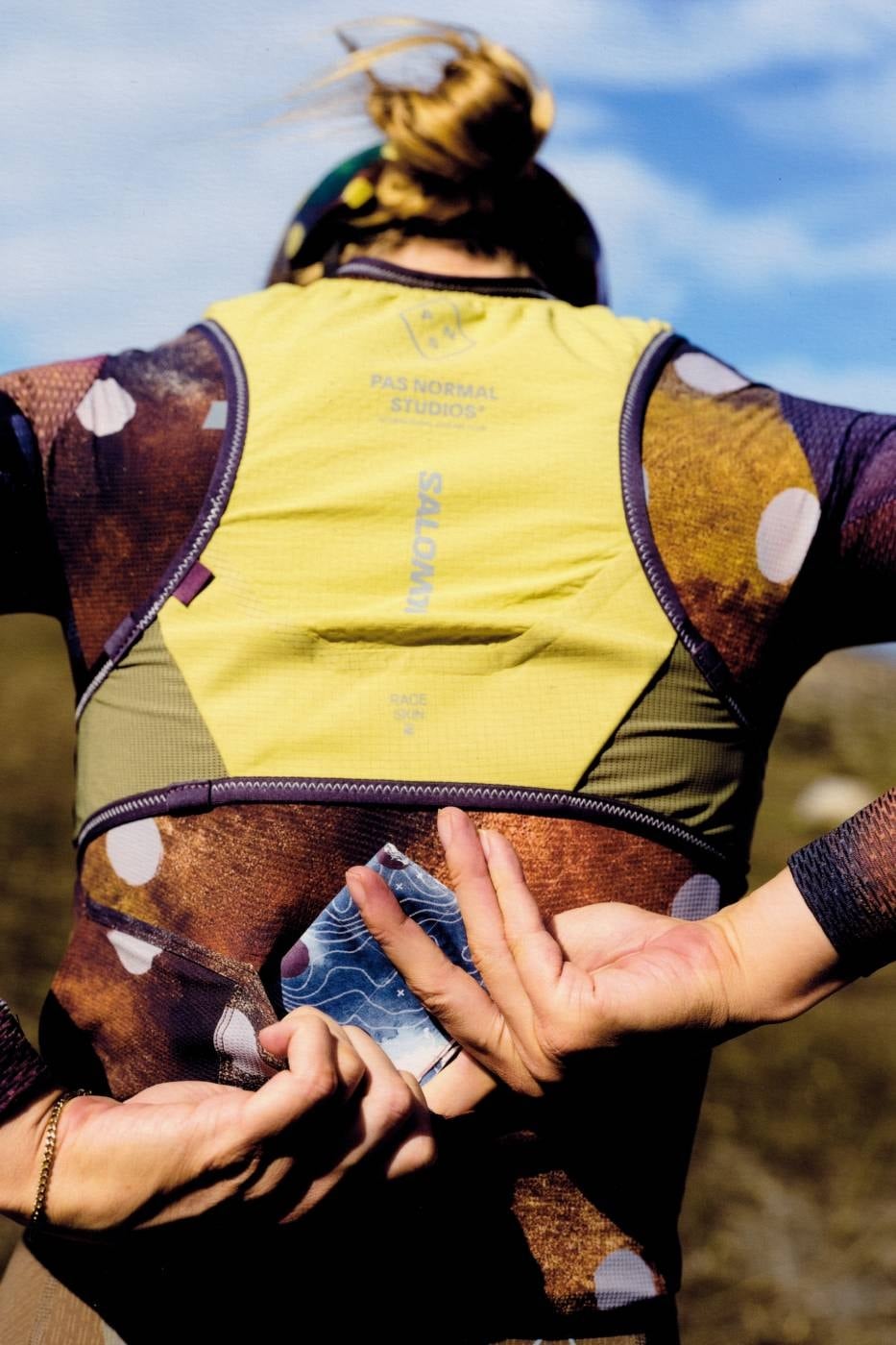 Rear view of the RACE SKIN 2 hydration vest with Pas Normal Studios and Salomon branding and a map-print pocket pull