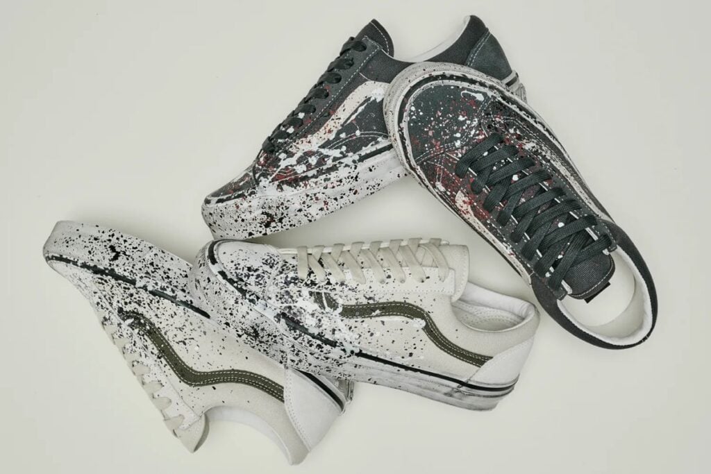 Both Old Skool 36 Paint Splatter colorways scattered together, charcoal and off-white with grease-aged foxing