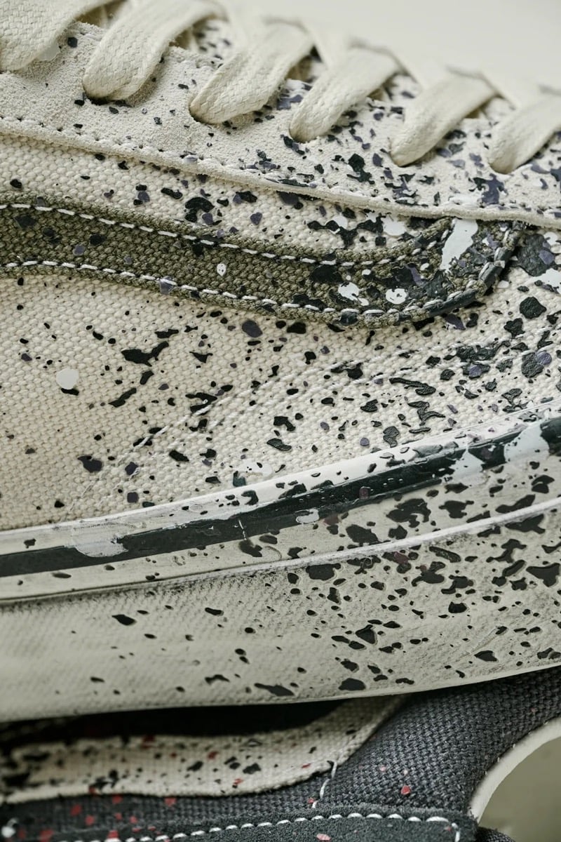 Close-up of black paint splatter scattered across the cream canvas of the Turtledove Old Skool 36