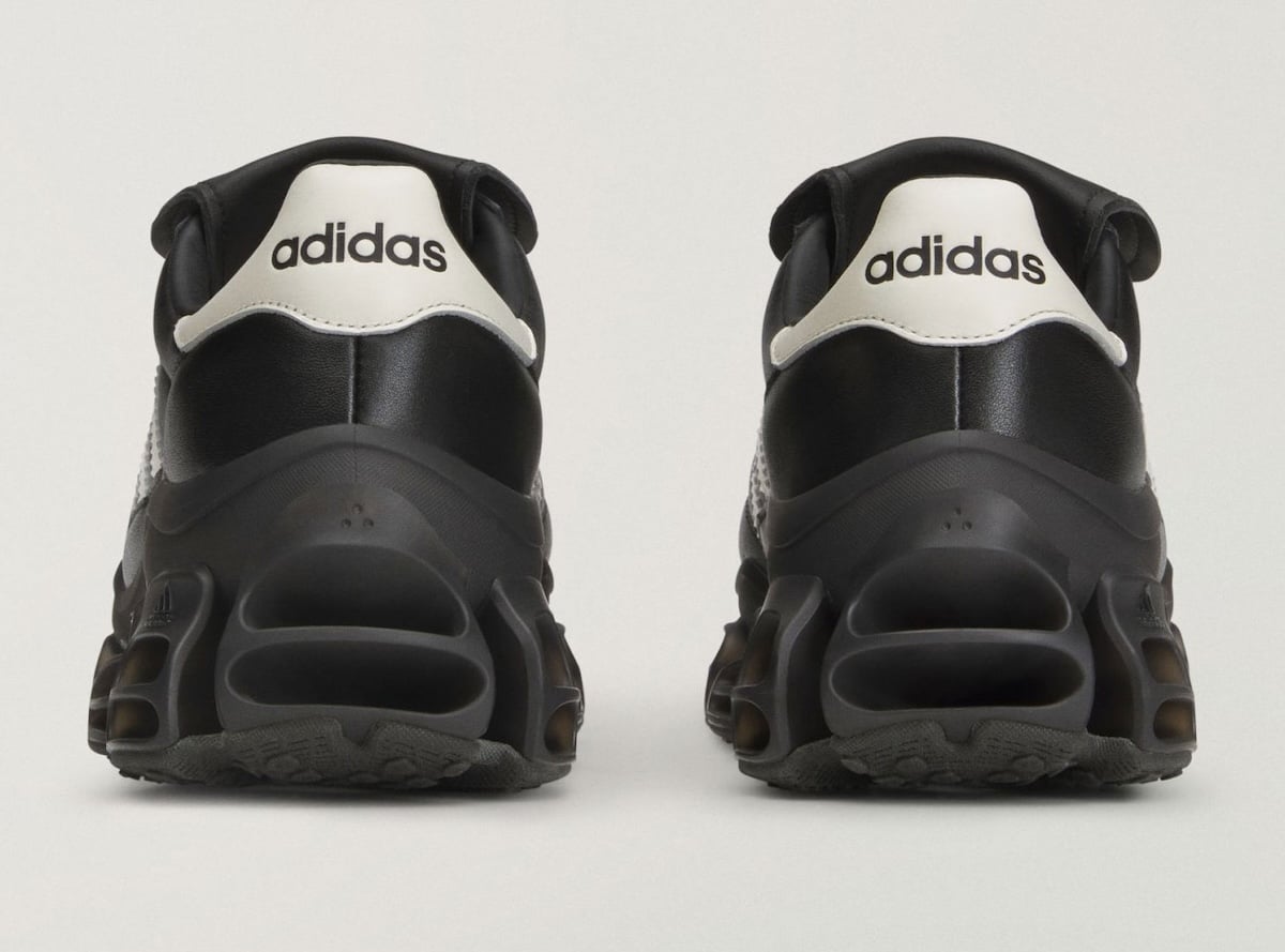 Rear heel view showing white heel counters with black adidas text above the stacked black Megaride sole