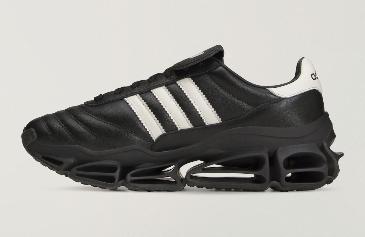 Medial side profile showing the white Three Stripes and the sculpted black Megaride platform with cut-out pods