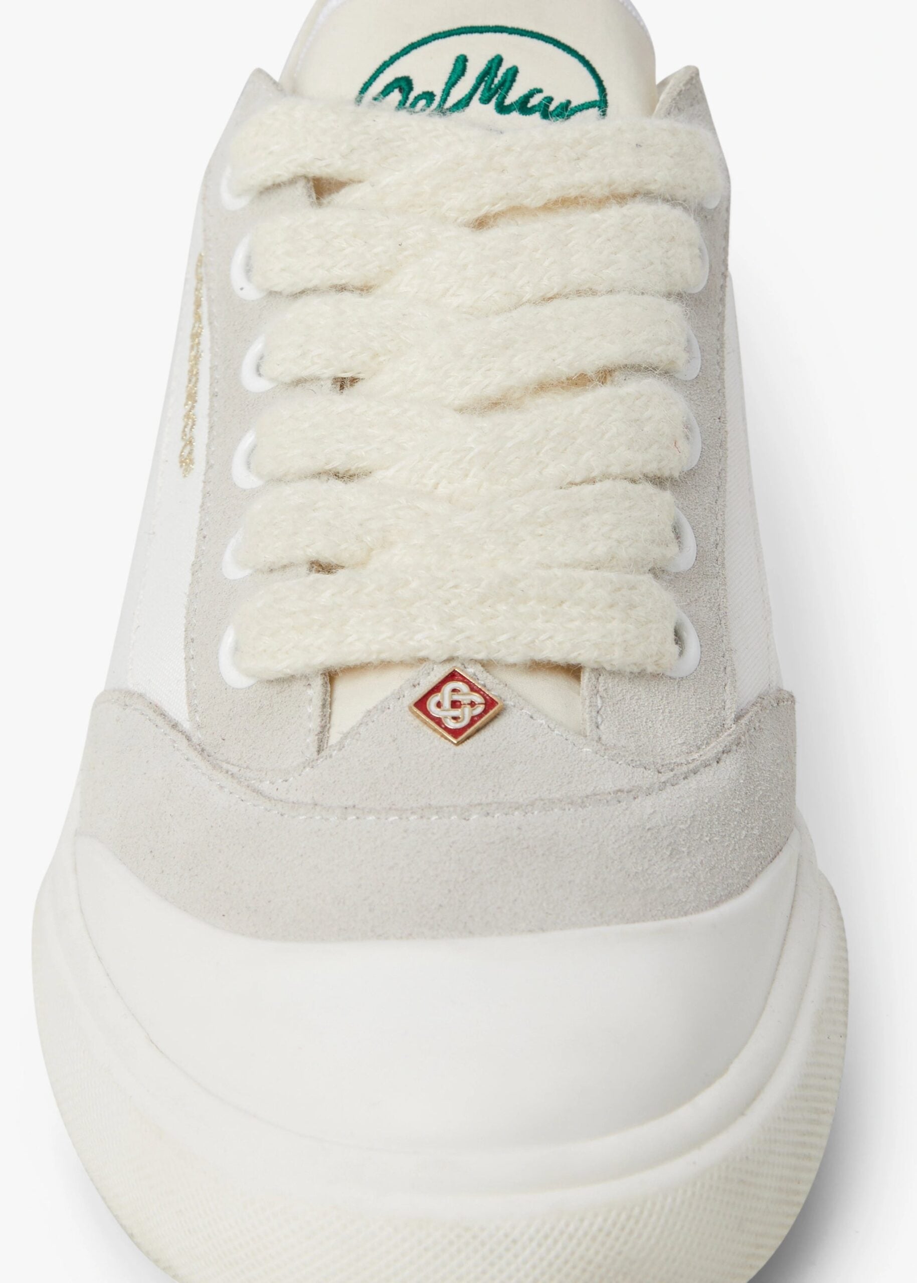 Close-up of the chunky cream laces and red diamond Casablanca monogram charm at the throat of the Del Mar