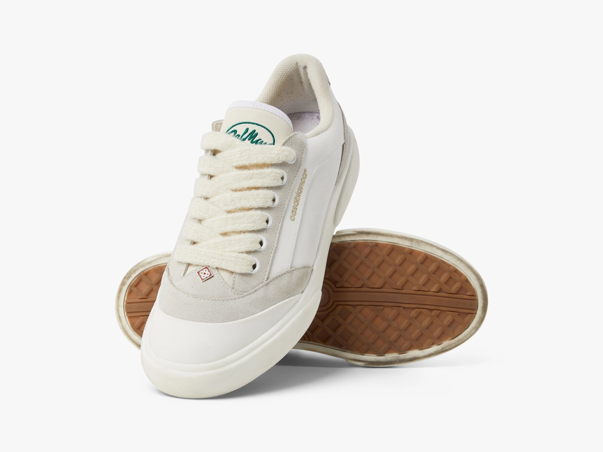 Top and outsole view of the Del Mar pair, with a green woven tongue logo and a gum-tinted waffle tread
