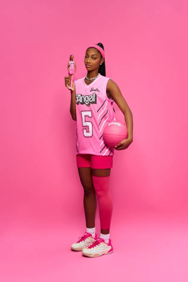 Angel Reese in a pink Angel No. 5 jersey holding the doll, part of the Barbie Reebok collaboration