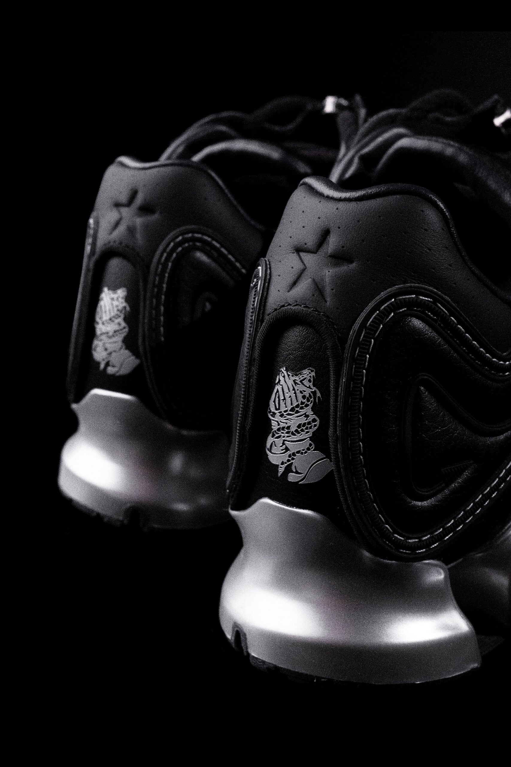 heel close-up, black leather with embossed star and small metallic graphic emblem, DIOS Megaride 01