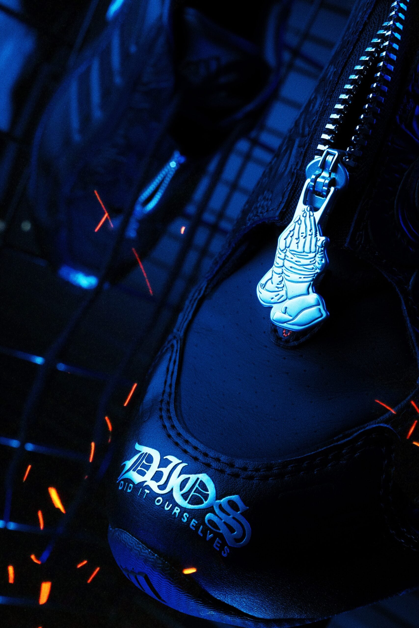 close-up of zipper pull shaped like clasped hands, DIOS wordmark on heel, DIOS Megaride 01