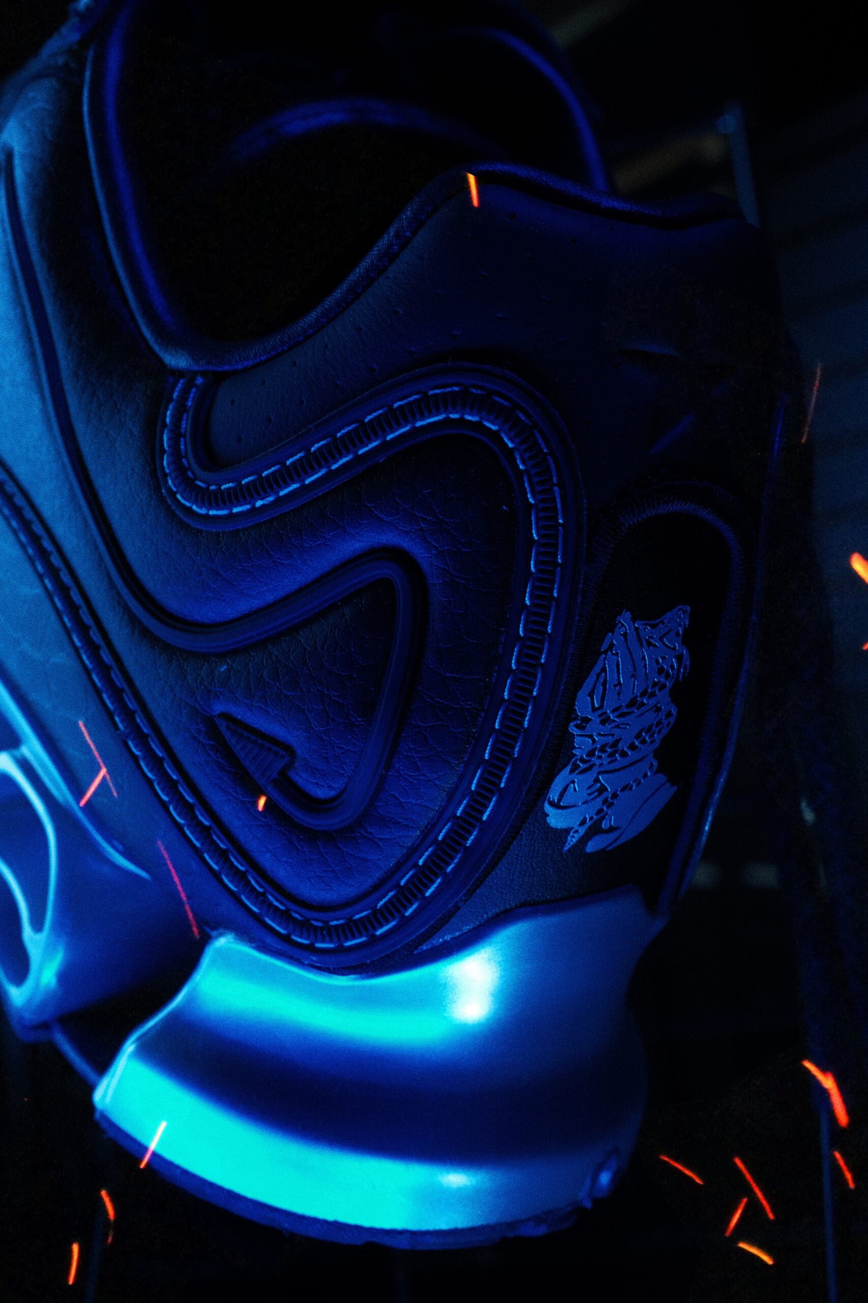 close-up of toe panel, snake-skin embossed texture beside glowing blue heel pod, DIOS Megaride 01