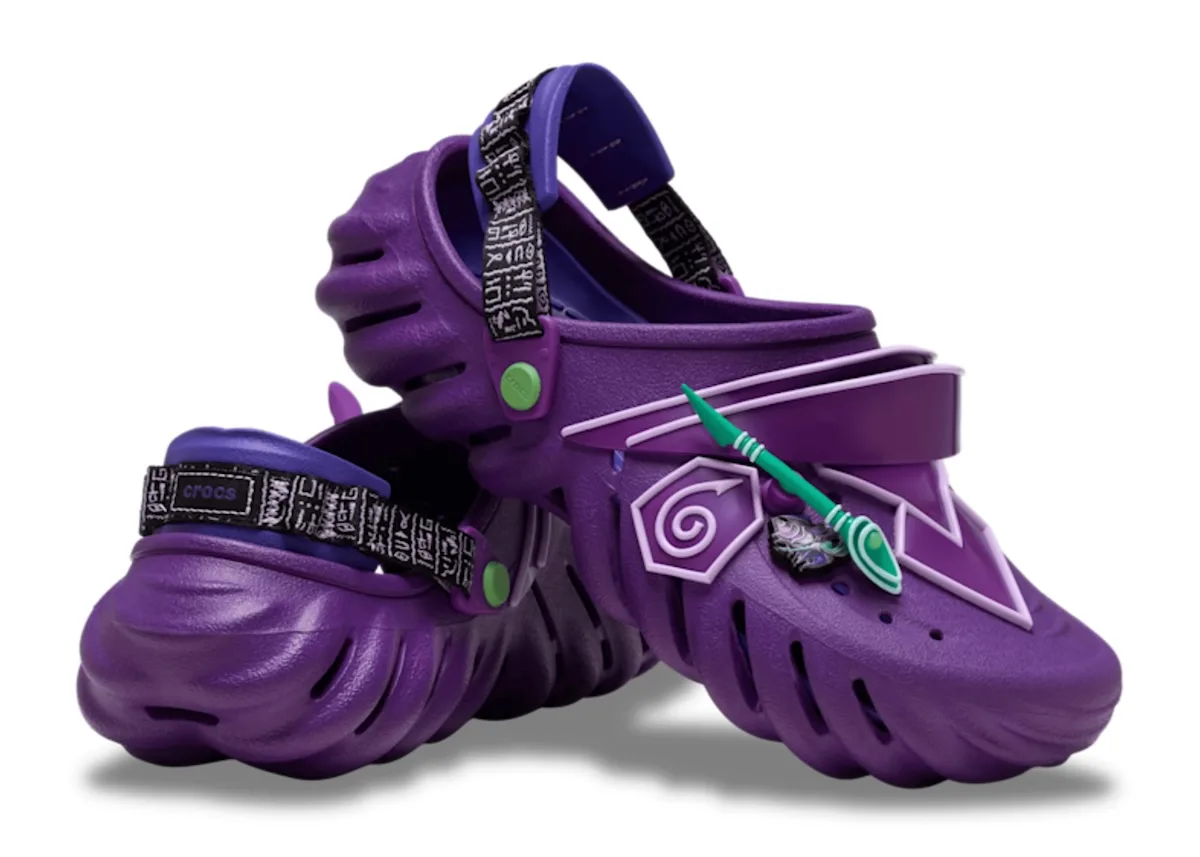 angled pair, purple spiky clogs with lilac swirl badges and teal arrow charms, x Crocs Collection