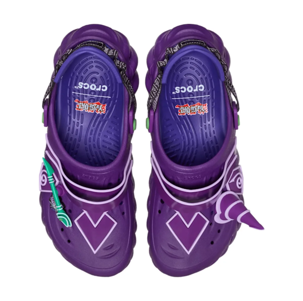 top-down pair, purple clog with lavender heart outline and teal arrow charm, x Crocs Collection