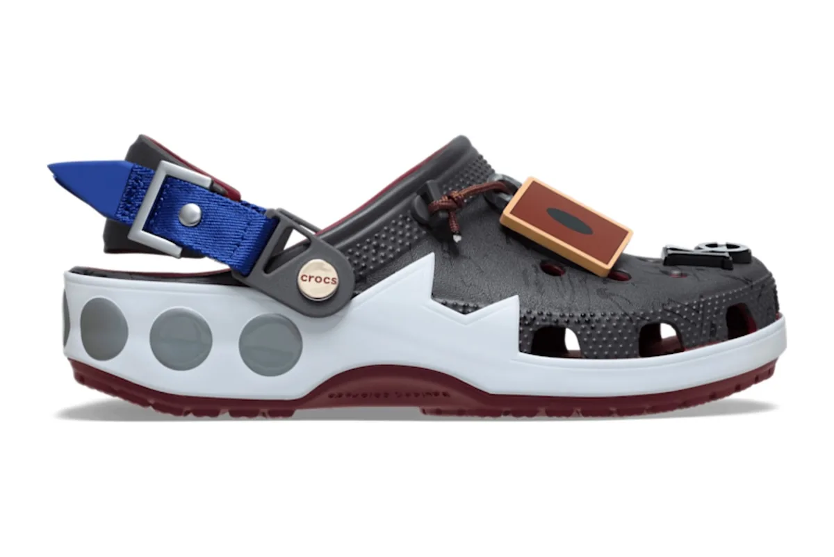 lateral view, grey and white clog with blue buckle strap and rust-coloured card charm, x Crocs Collection