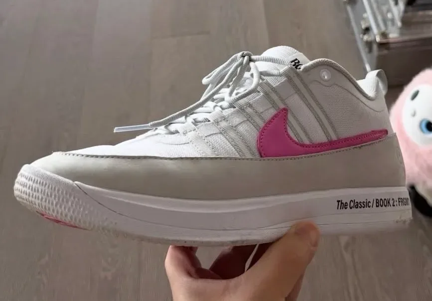lateral close-up in-hand, white upper, grey suede toe, pink swoosh, White and Pink