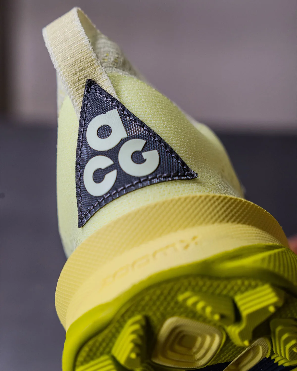 Heel close-up, ACG triangle patch on pale green upper with yellow foam midsole, Nike ACG Picklejus
