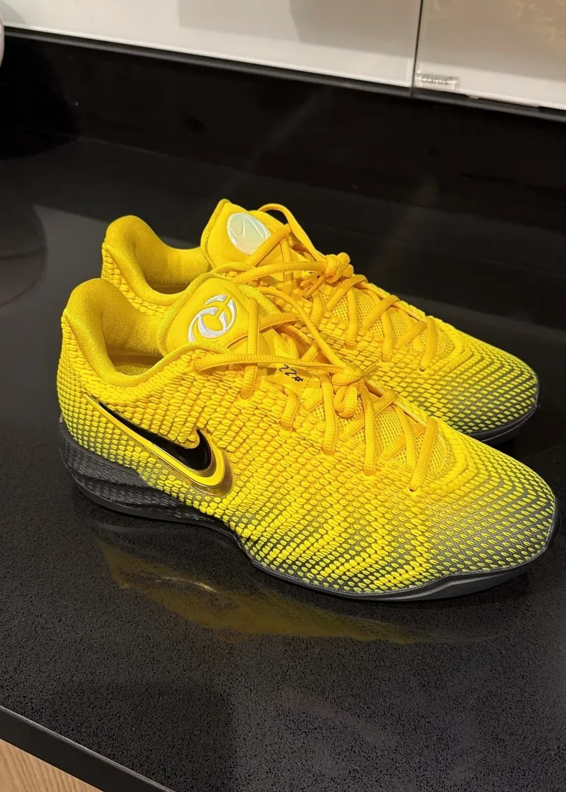 pair, lateral view, yellow woven upper fading to black midsole, black swoosh, glossy surface, Yellow
