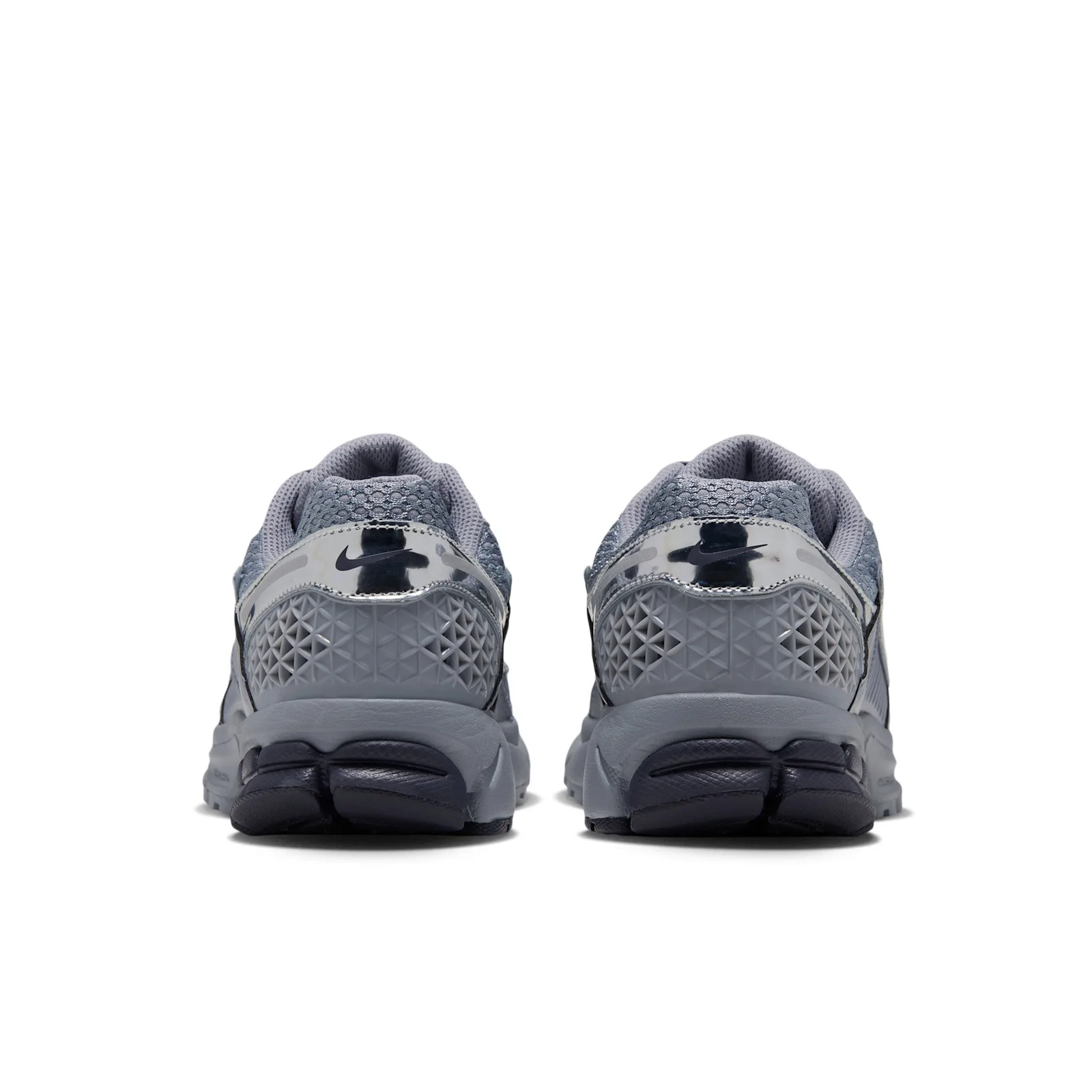 heel view of pair, silver Nike logo tab above dark navy ridged outsole, Gridiron