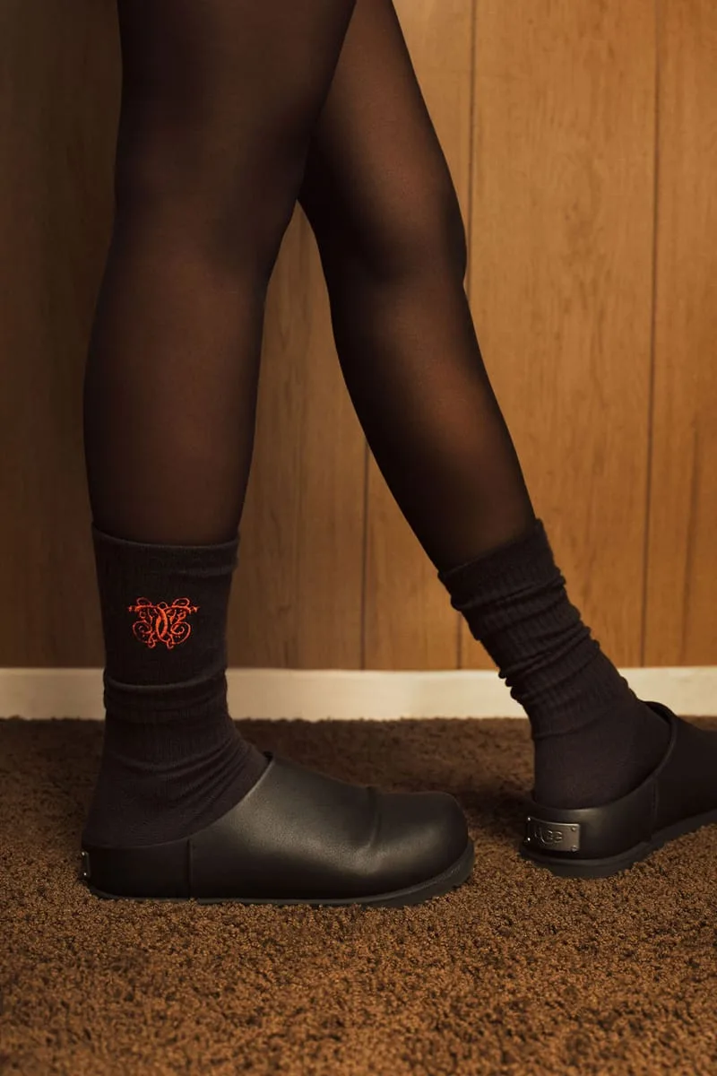 on-foot close-up, black ribbed socks with red emblem worn with black mules, Willy Chavarria Collection