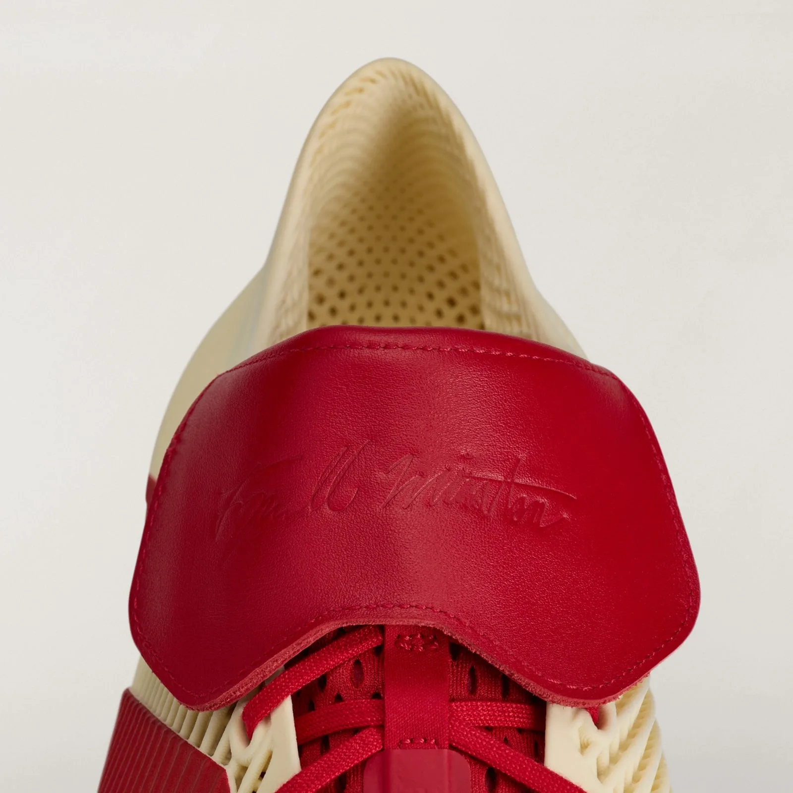 close-up of red leather heel tab embossed with a signature, Collegiate Red