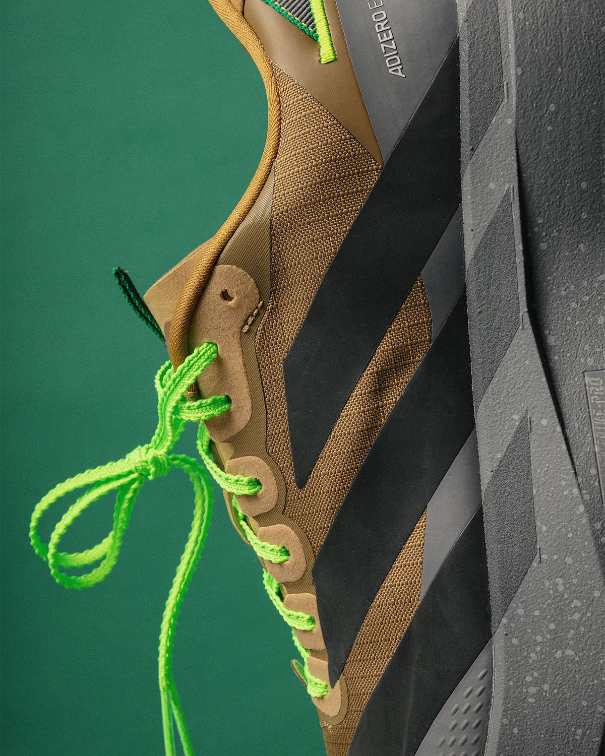 heel and collar close-up, brown suede, black overlay, green laces and pull loop, x Up There