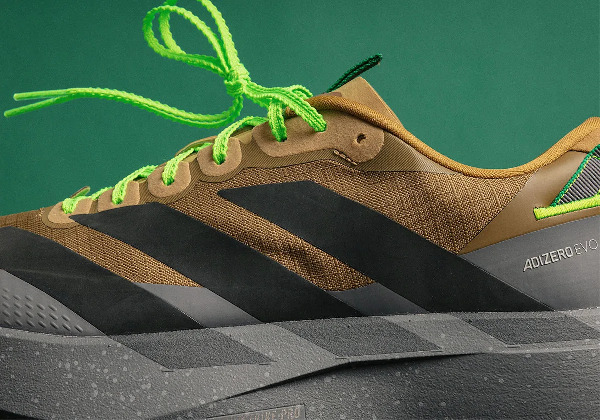 close-up of black stripe overlay on brown upper with ADIZERO EVO text, x Up There