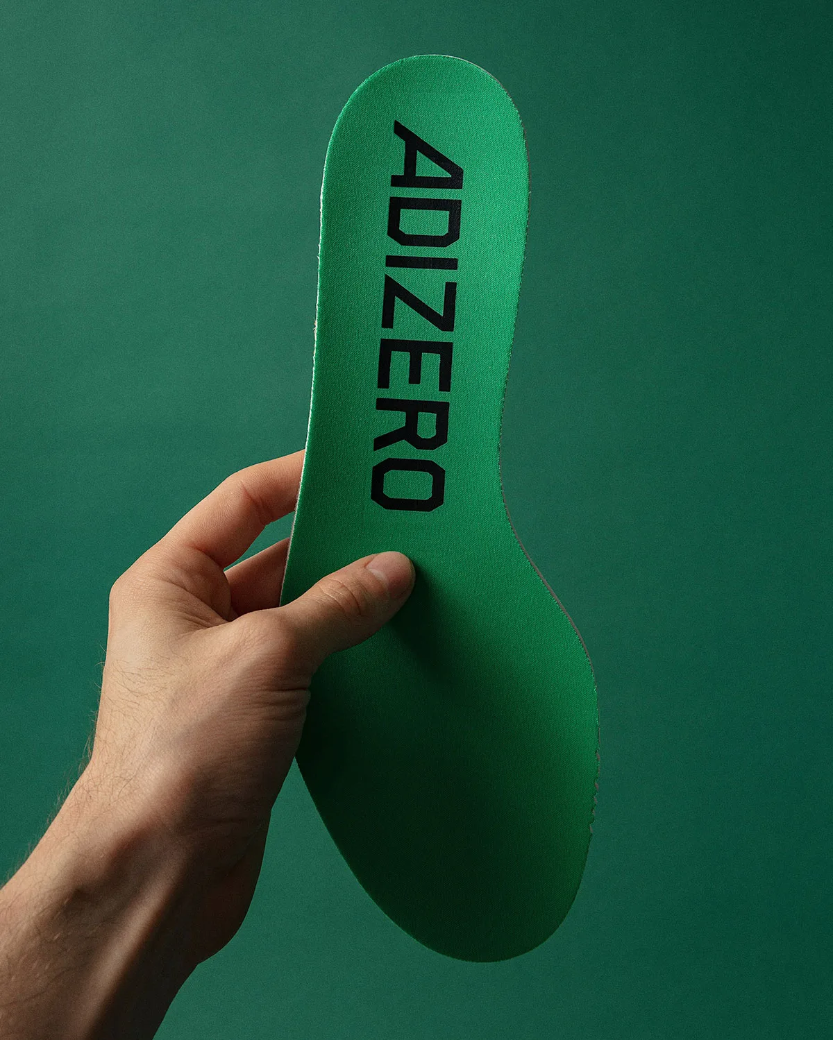 green insole in hand printed with black ADIZERO text, x Up There