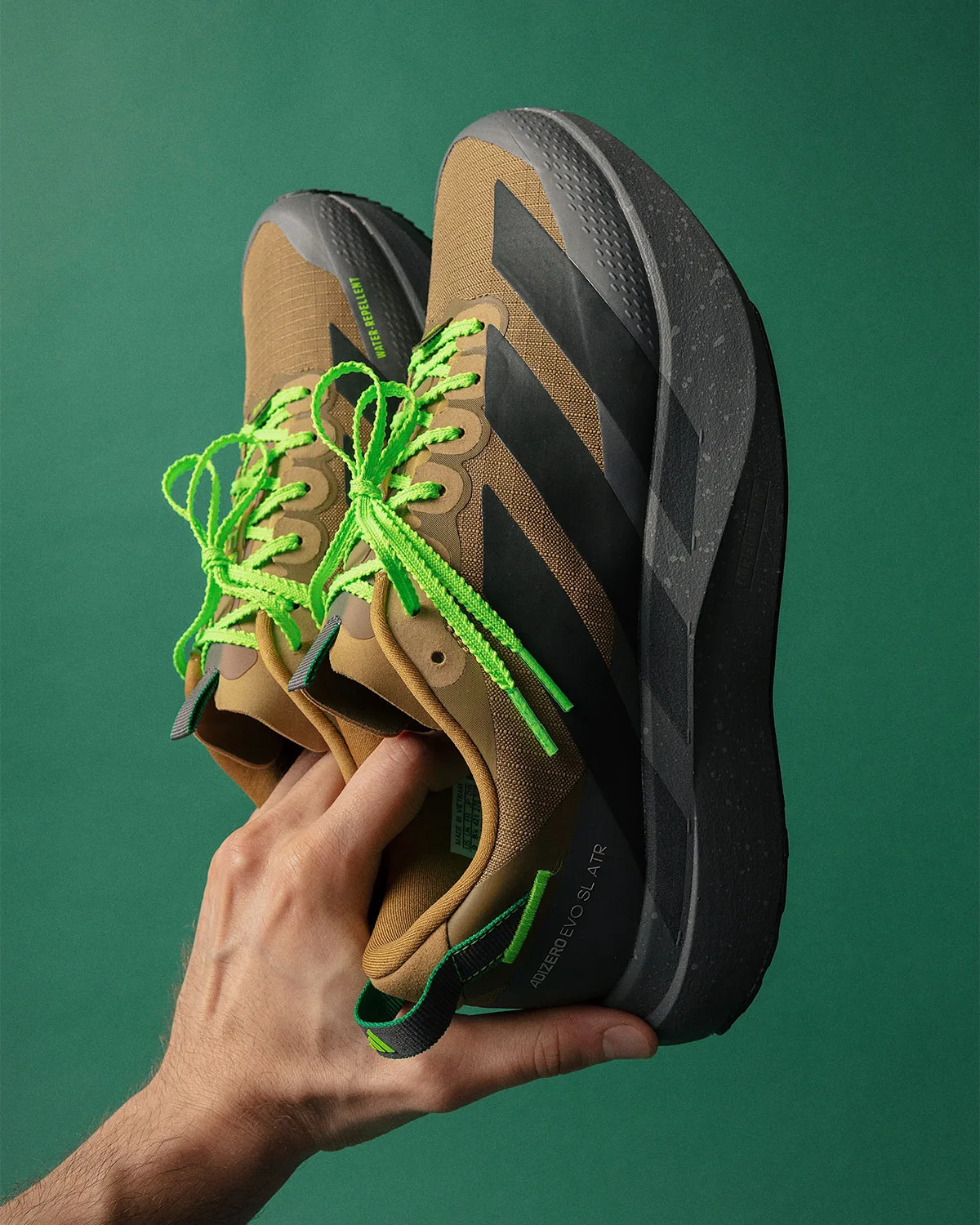 lateral pair in hand, brown upper with black stripes, speckled gray midsole, x Up There